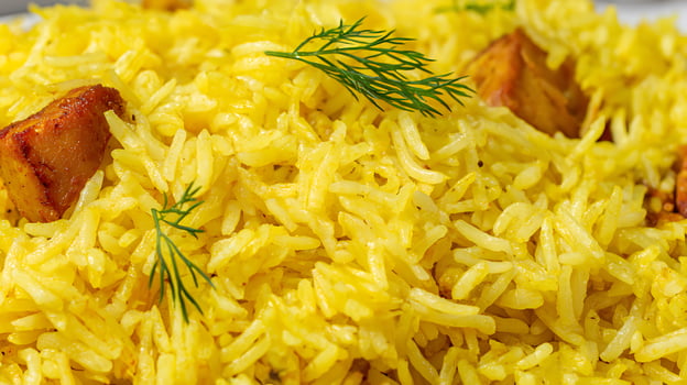 Close up of appetizing yellow rice with meat and fresh dill. photo