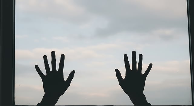 Silhouetted Hands Reaching Towards Sky Behind Window in Silhouette Style photo