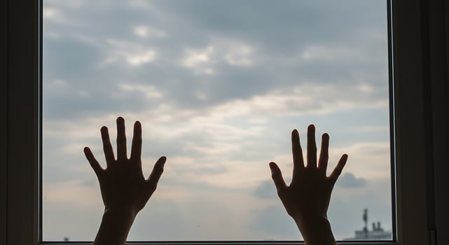 Silhouette Hands Reaching Toward Cloudy Sky Through Window photo