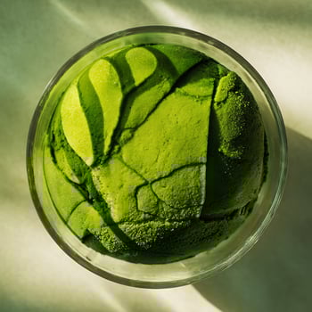 Vibrant Green Matcha Ice Cream in a Clear Glass Bowl with Sunlight. photo