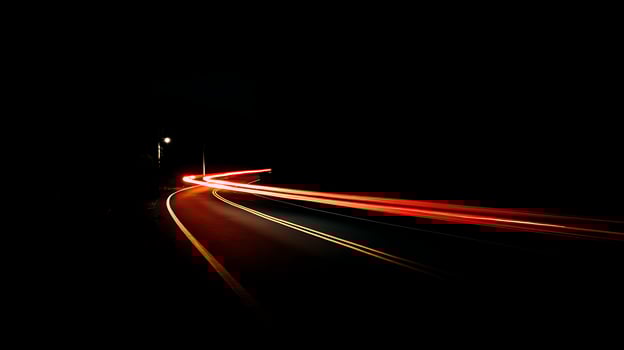 Streaks of light paint the night as cars speed along a dark road. photo