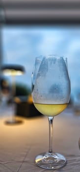A glass of chilled white wine against a blurred background in a restaurant on the Ligurian Riviera photo