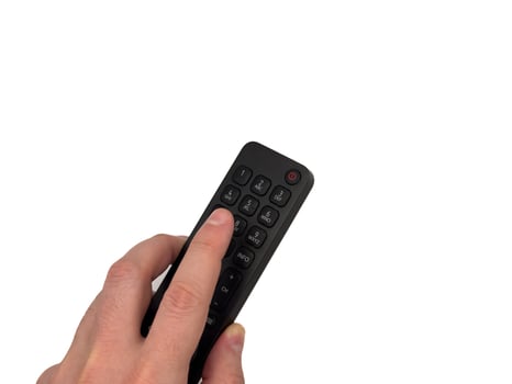 hand on white background presses buttons on TV remote control, switches TV channels for banners, for TV advertising. Copy space, flay lay, top view. photo