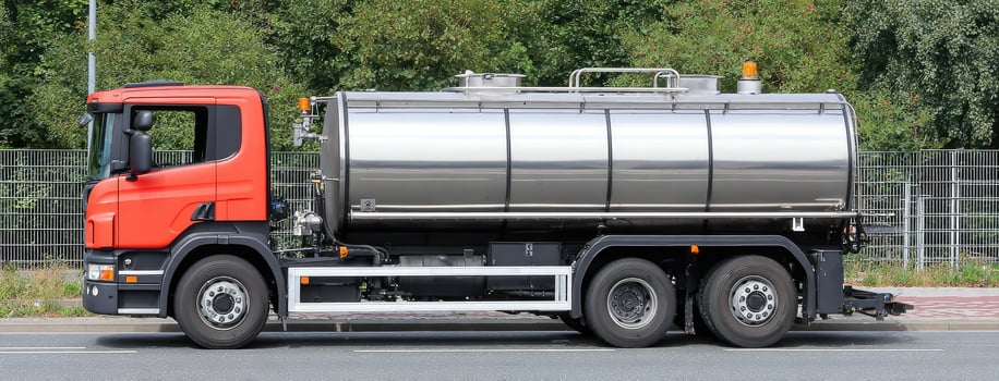 A large tanker truck is parked on the side of the road photo