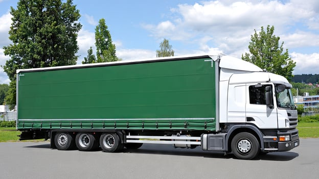A large green truck parked on a street photo