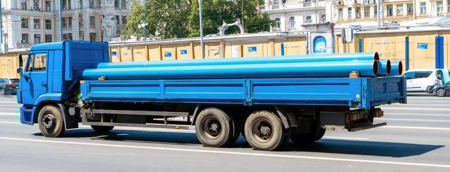 A blue truck with a large pipe on the back photo