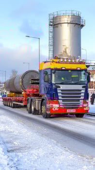 A large truck driving down a snowy road photo