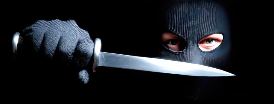 A person in a black mask holding a knife photo