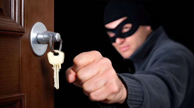 A burglar is holding a key to a door photo