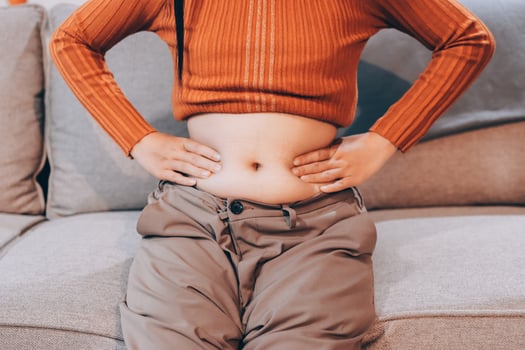 A woman sitting on a couch with her stomach on the floor photo