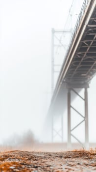 Ethereal Bridge Structure Piercing Through Dense Fog A Muted Architectural Grandeur Amidst a Serene, Atmospheric Landscape View photo