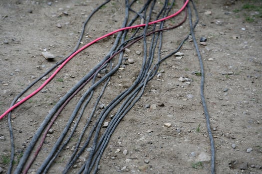 At the Flensburg dragon boat race, cables lie in the sandy ground, they are black and a red photo