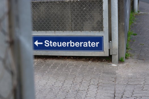 A sign in German for a tax consultant office with a directional arrow photo