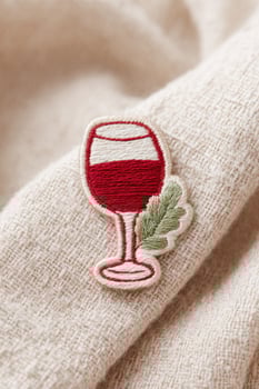 Embroidered wine glass patch decorating beige cloth photo