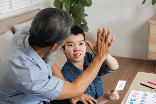 Learning and Engagement. A grandfather teaching his grandchild with Down syndrome through interactive activities. photo