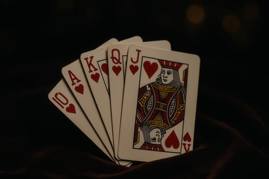 Royal flush of hearts playing cards on dark background photo