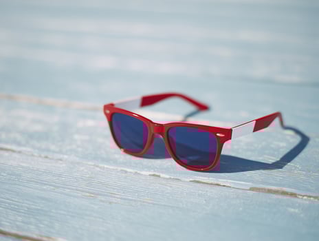 Red and White Sunglasses on Blue Wood Surface photo