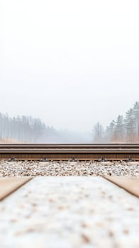 A serene and atmospheric view of railroad tracks disappearing into a misty forest, evoking a sense of quiet journey and natural solitude. photo