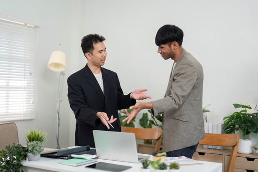 Professional Collaboration and Document Review. Two men discussing key points while reviewing documents in a modern office. photo