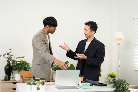 Business Interaction and Strategy Planning. Colleagues discussing project details and strategies at a stylish office desk. photo