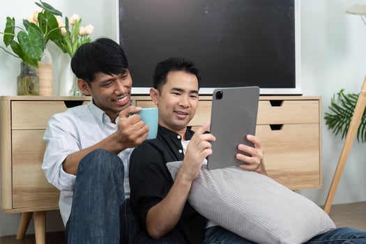 LGBTQ Togetherness and Joy. Two men enjoying a light-hearted moment while using a tablet. photo