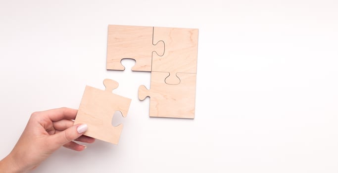 Woman creating wooden puzzle of four pieces with copy space for text on white background, panorama photo
