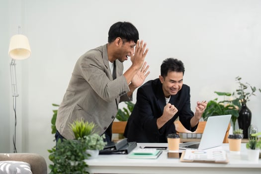 Joy and Team Spirit. Two professionals celebrating a successful project outcome with enthusiasm in a bright office space. photo