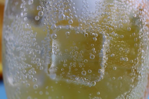 Lemonade water divorcing in a glass of ice and orange is very close-up. Macrophoto photo