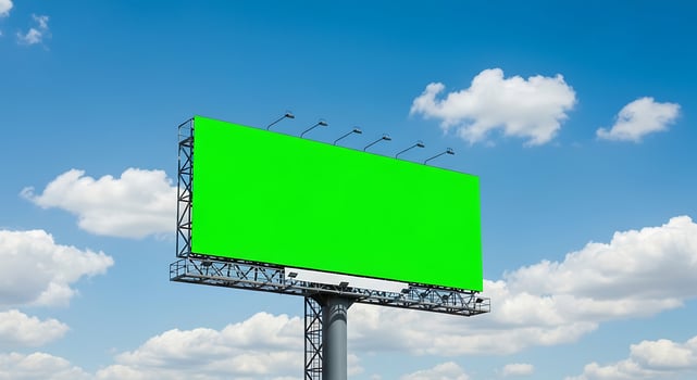 Large green screen billboard with blank space against bright blue sky and scattered clouds photo