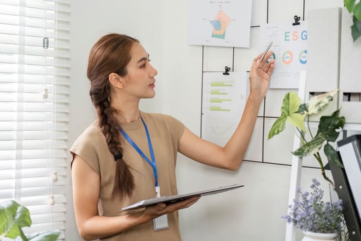 ESG sustainability management with woman reviewing metrics on wall photo