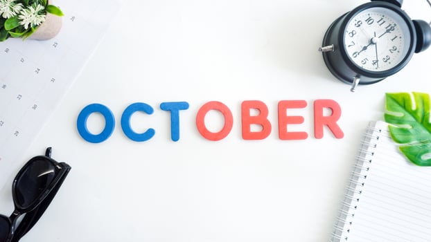 Flat lay composition with red and blue color foam letters spelling word OCTOBER isolated on white background photo
