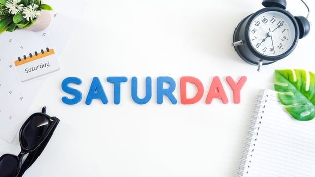 Flat lay composition with blue and red color foam letters spelling word SATURDAY isolated on white background photo