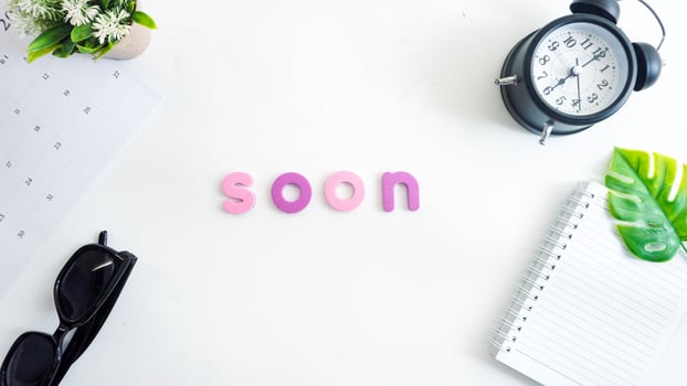 Flat lay composition with colorful foam letters spelling text SOON isolated on white background photo