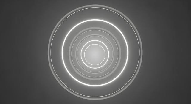 A circular light is shown in the middle of a dark background photo