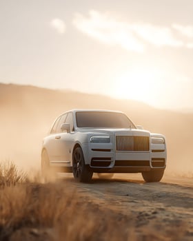 Luxury SUV on Desert Road with Blowing Sand and Soft Focus Background photo
