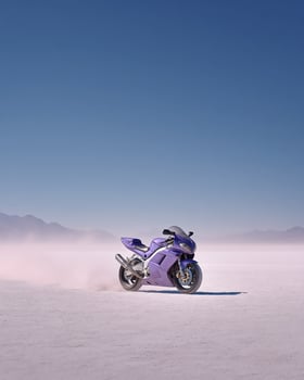 High Speed Purple Motorcycle on Salt Desert Plain With Kicking Dust and Clean Sky Captured in Minimal and Modern Framing photo