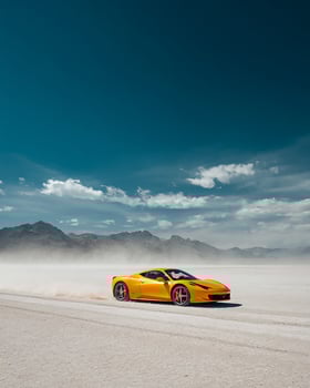 Action Image of Yellow Race Car Speeding on White Salt Desert With Flying Dust and Minimal Clean Background for Automotive and Ad Campaign Uses photo