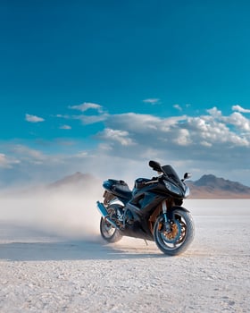 Powerful Black Motorcycle Speeding Across Desert Salt Flat in Harsh Light and Clean Sky, Highlighting Motion and Isolated Subject for Advertising photo