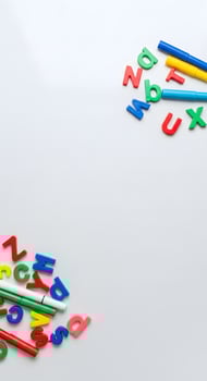 Colorful alphabet letters and pencils on a white surface photo