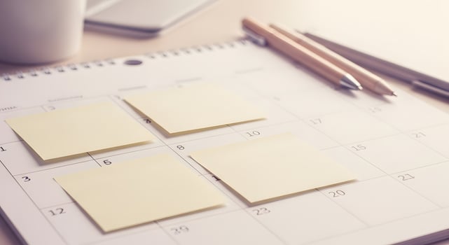 Calendar with sticky notes and coffee cup on desk photo