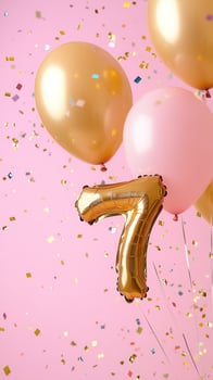 Celebrating a confetti birthday or anniversary with gold and pink balloons and 7th on a pink background photo