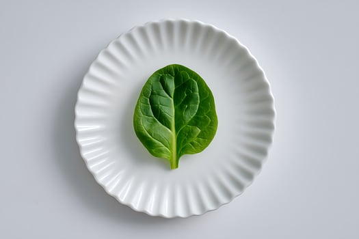 Fresh Green Spinach Leaf on White Ruffled Plate Minimalist Vegetarian Food Presentation photo