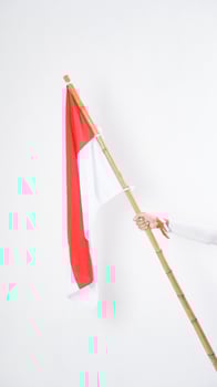 Hand waving red and white Indonesia flag color attribute holding Indonesia flag to celebrate Indonesia independence day celebration isolated on white background photo