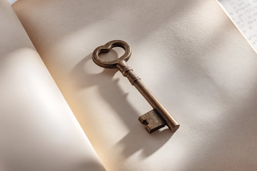 Vintage Metal Key Resting on Open Book with Soft Lighting in Cozy Atmosphere photo
