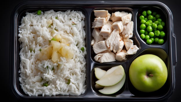 This meal consists of rice, chicken, and green peas paired with apple slices and water, designed for those managing diabetes, offering balanced nutrition. photo