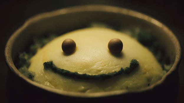 Cute smiley face mashed potatoes and vegetables in a bowl. photo