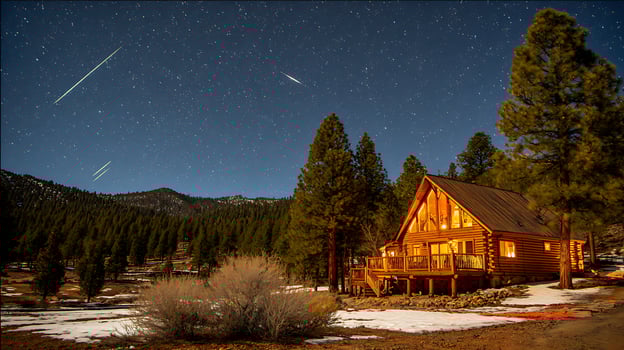 Cozy cabin under a sky full of shooting stars and pine trees. photo