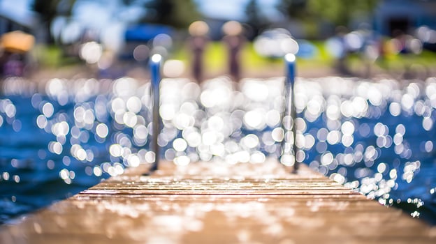 Sunlit Dock on Sparkling Water with Soft Bokeh Lights. photo