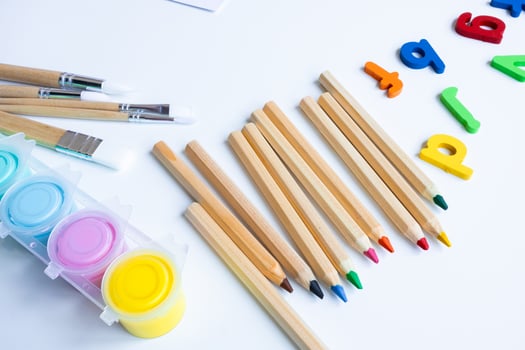 Colorful art supplies with brushes, pencils, and magnetic letters on white background photo