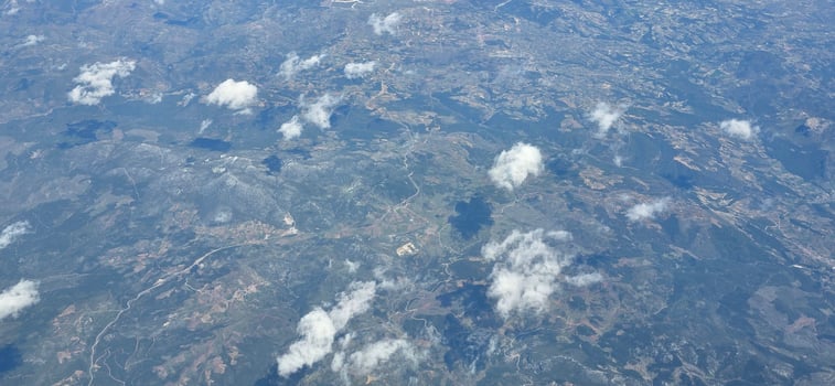 Aerial view of textured landscape with clouds and blue sky showcasing natural beauty and patterns photo